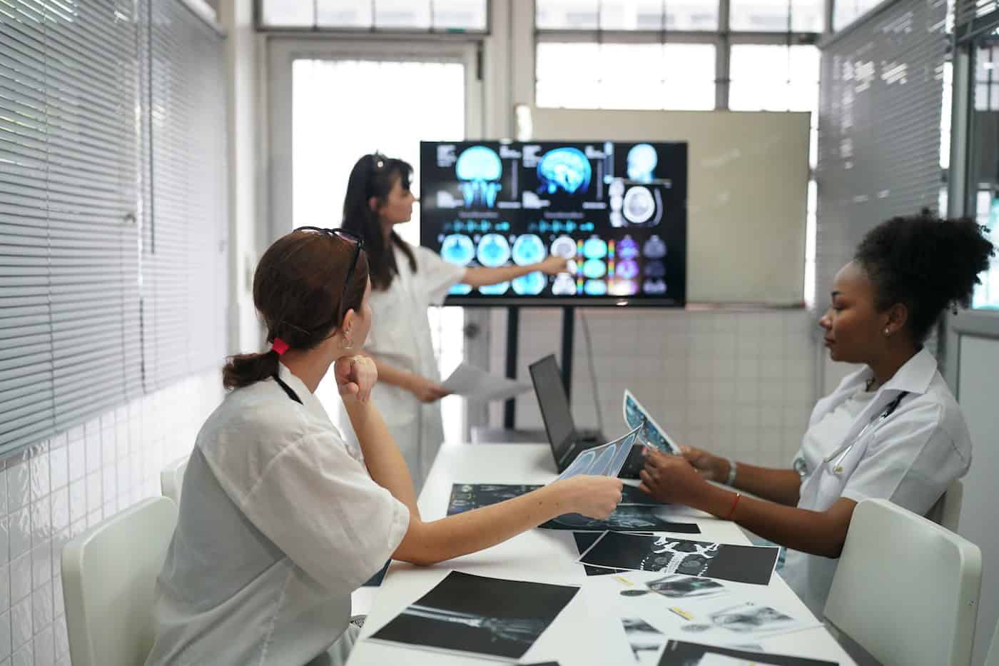 Healthcare staff discussing information beside a large display