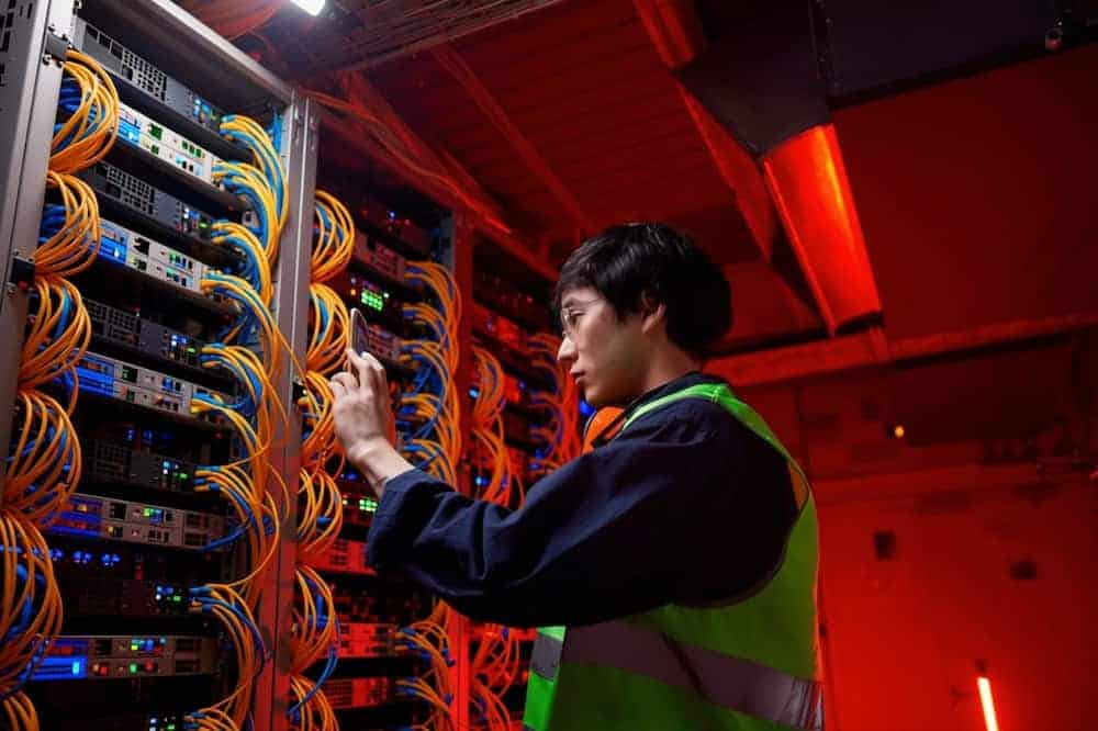 Technician checking connections in an equipment rack